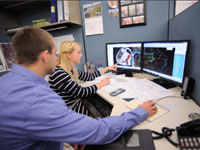 Interns working on computer maps.