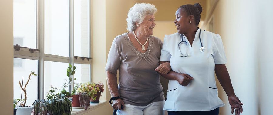 Nurse walking patient down the hall.