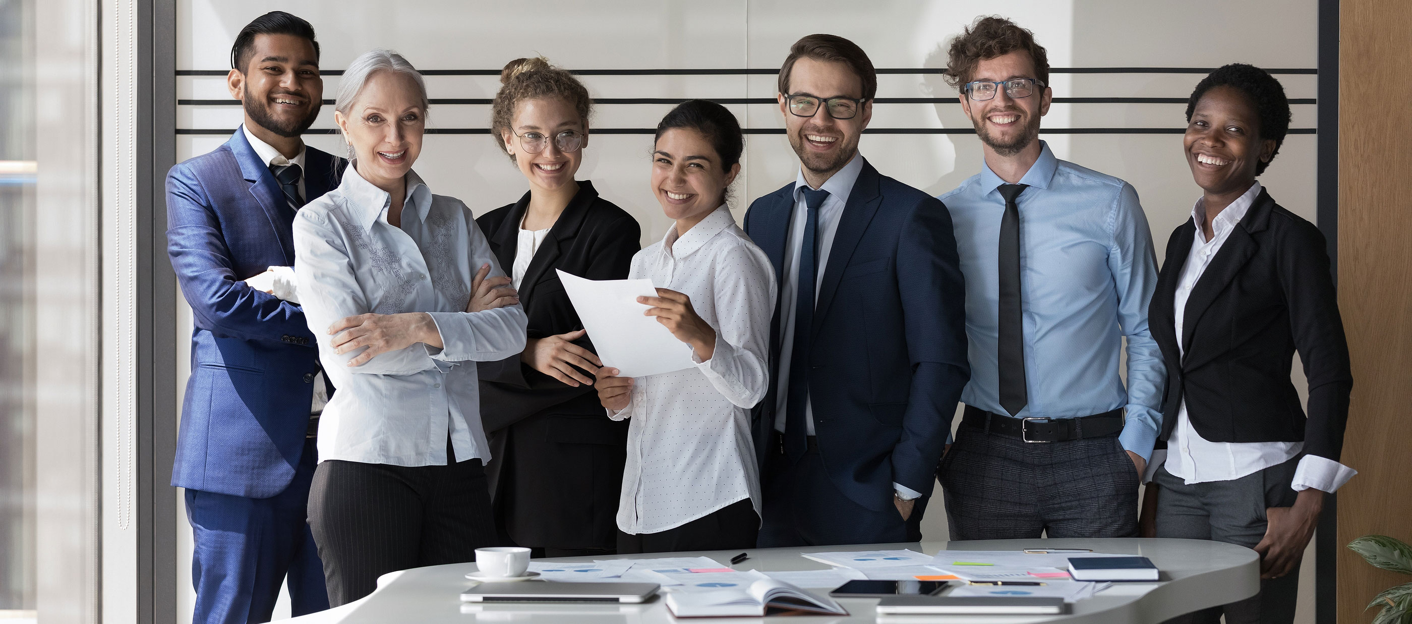 A group of diverse professionals sitting at a table interviewing a potential employee.